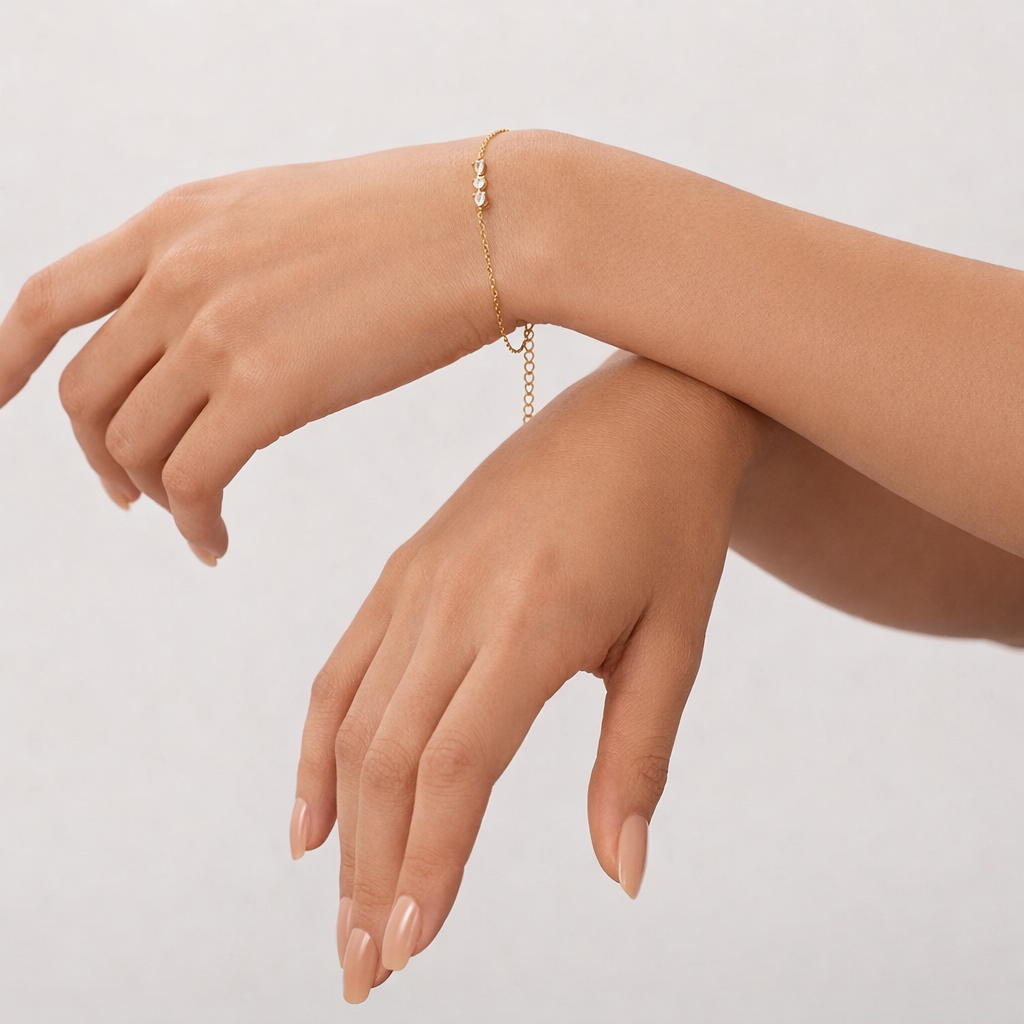 Gold bracelet on a person's wrist with a plain background