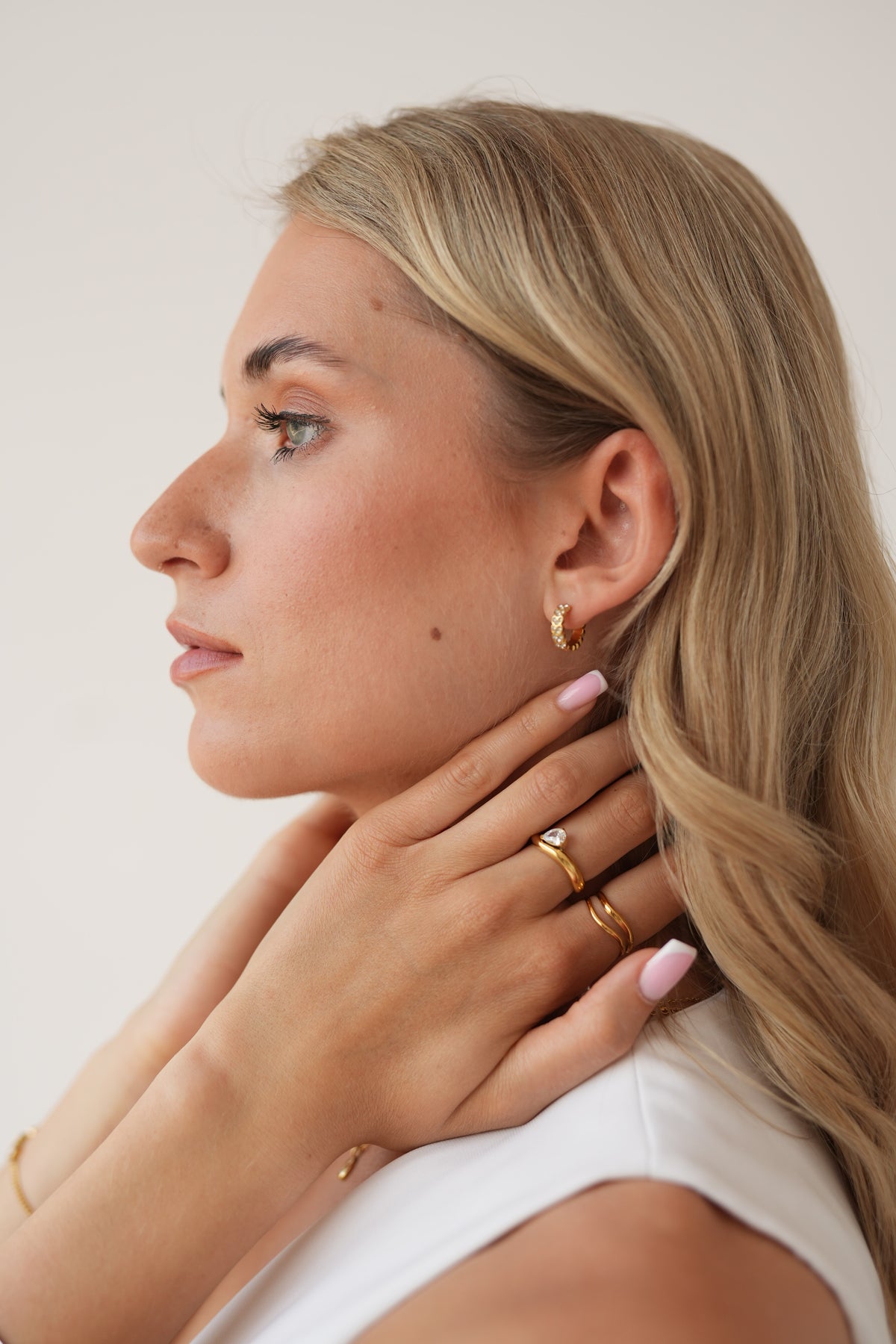 Gold hoop earring shown in a close-up portrait.