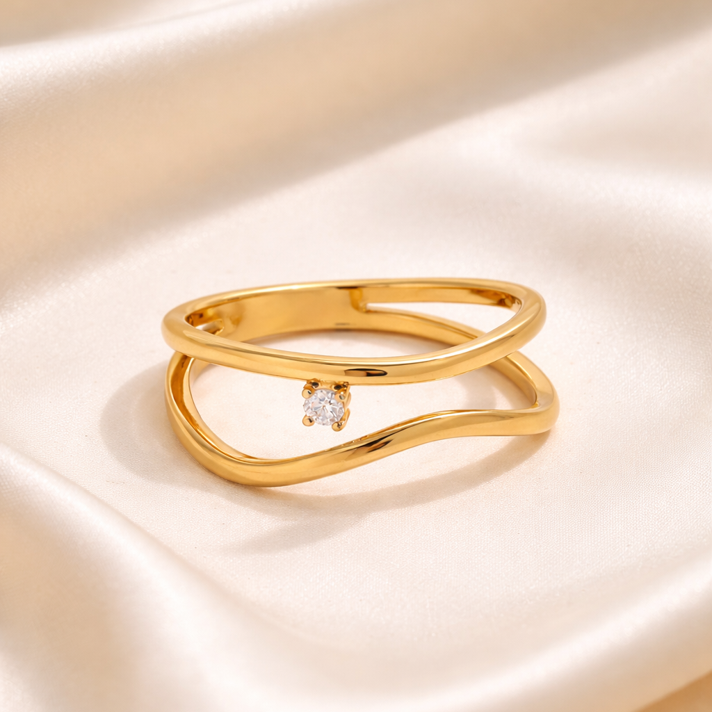 Gold ring with a small diamond on a beige satin background